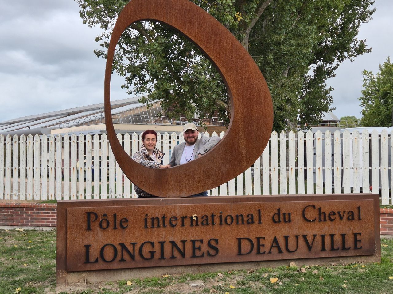 Two of the EHOSS team framed in the opening of the Corten sculpture above the Pôle International du Cheval Longines-Deauville sign