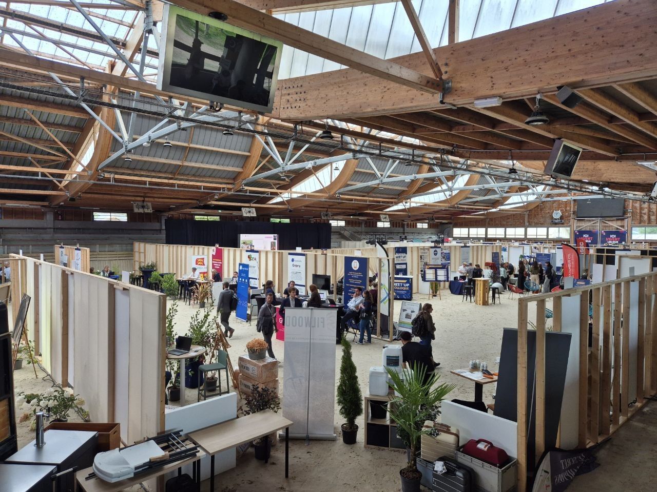 The covered arena turned over to the event, timber-framed stands standing on the sand under the hall's wooden roof