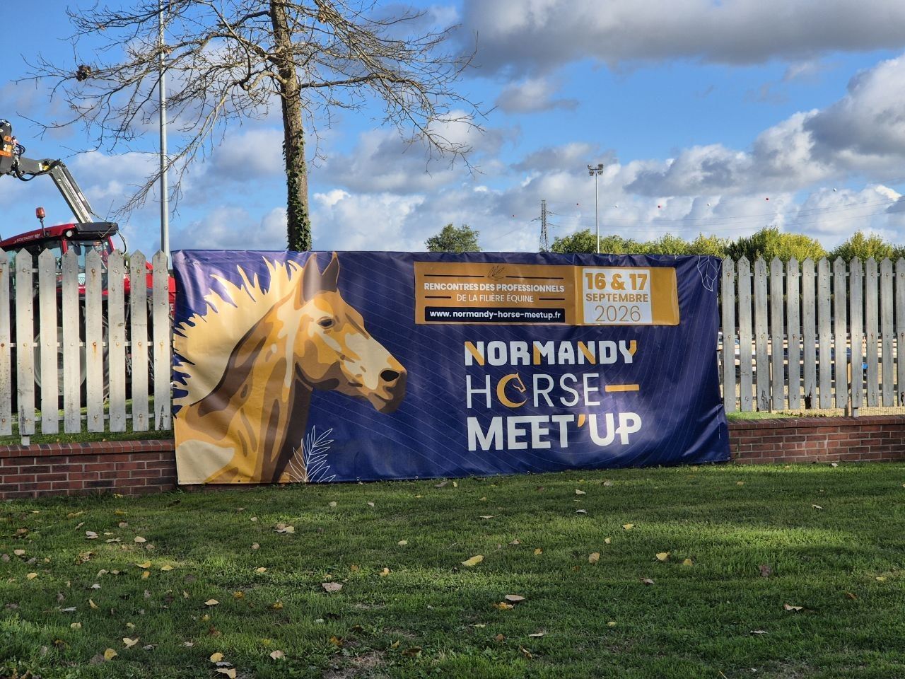 The Normandy Horse Meet’Up banner hung on the white paddock fence, an illustrated horse's head beside the dates 16 and 17 September 2026